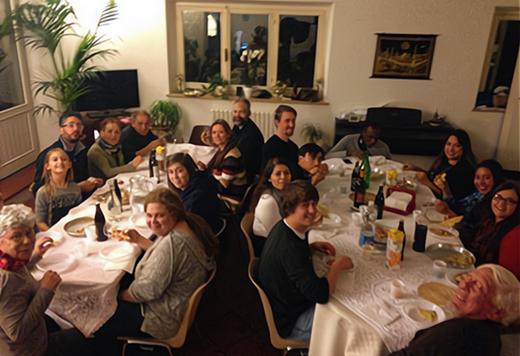 A large group of people sitting around two tables in a dimly lit room